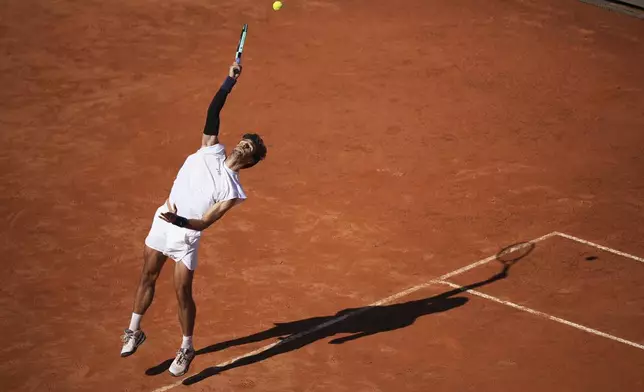 Italy's Lorenzo Musetti returns the ball to Spain's Carlos Alcaraz during their semifinal tennis match at the Italian Open, in Rome, Friday, May 16, 2025. (AP Photo/Andrew Medichini)