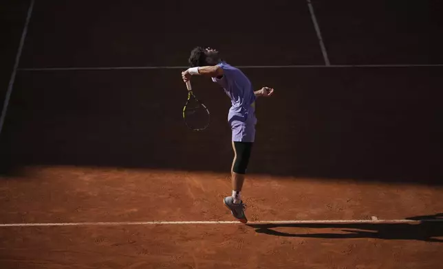 Spain's Carlos Alcaraz serves the ball to Italy's Lorenzo Musetti during their semifinal tennis match at the Italian Open, in Rome, Friday, May 16, 2025. (AP Photo/Andrew Medichini)