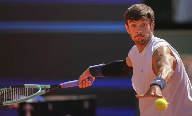 Italy's Lorenzo Musetti returns the ball to Spain's Carlos Alcaraz during their semifinal tennis match at the Italian Open, at the Foro Italico, in Rome, Friday, May 16, 2025. (AP Photo/Andrew Medichini)