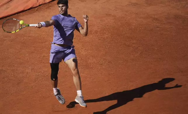 Spain's Carlos Alcaraz returns the ball to Italy's Lorenzo Musetti during the semifinal tennis match at the Italian Open, in Rome, Friday, May 16, 2025. (AP Photo/Andrew Medichini)