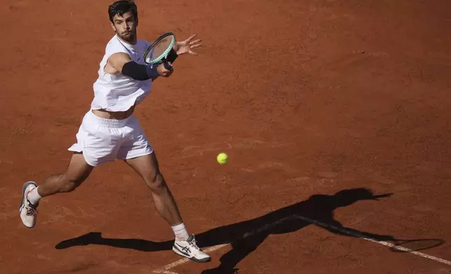 Italy's Lorenzo Musetti returns the ball to Spain's Carlos Alcaraz during their semifinal tennis match at the Italian Open, in Rome, Friday, May 16, 2025. (AP Photo/Andrew Medichini)
