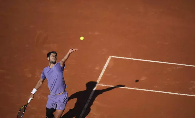 Spain's Carlos Alcaraz serves the ball to Italy's Lorenzo Musetti during their semifinal tennis match at the Italian Open, in Rome, Friday, May 16, 2025. (AP Photo/Andrew Medichini)
