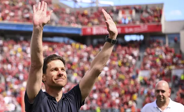 Leverkusen's head coach Xabi Alonso waves to the fans before the German Bundesliga soccer match between Bayer 04 Leverkusen and Borussia Dortmund in Leverkusen, Germany, Sunday, May 11, 2025. (Marius Becker/dpa via AP)