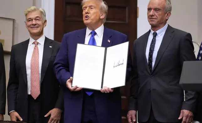 President Donald Trump, with Dr. Mehmet Oz, Administrator of the Centers for Medicare &amp; Medicaid Services, left, and Health and Human Services Secretary Robert F. Kennedy Jr., right, holds an executive order related to drug prices, in the Roosevelt Room of the White House in Washington, Monday, May 12, 2025, in Washington. (AP Photo/Mark Schiefelbein)
