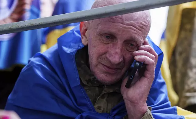 A Ukrainian soldier speaks by a phone to his relative after returning from captivity in a POW exchange in Ukraine, Tuesday, May 6, 2025. (AP Photo/Evgeniy Maloletka)