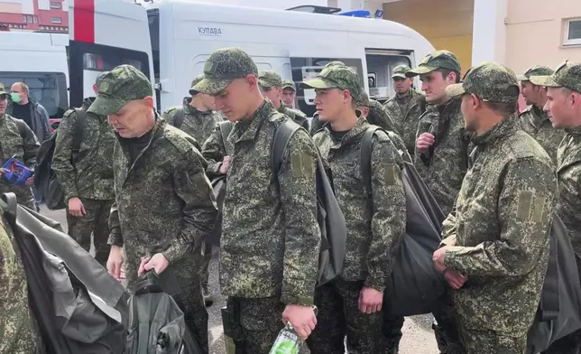 In this photo taken from video distributed by Russian Defense Ministry Press Service on Tuesday, May 6, 2025, a group of Russian board a bus after being released in a prisoners swap between Russia and Ukraine, at the Ukraine-Belarusian boarder. (Russian Defense Ministry Press Service via AP)