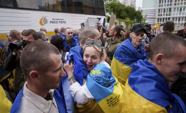 A Ukrainian soldier hugs a woman after returning from captivity in a POW exchange in Ukraine, Tuesday, May 6, 2025. (AP Photo/Evgeniy Maloletka)