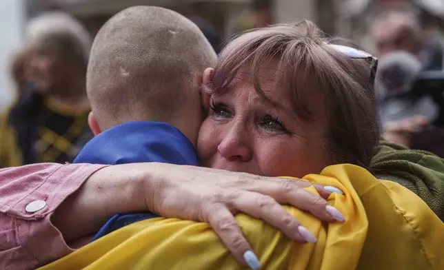 A Ukrainian soldier hugs a woman after returning from captivity in a POW exchange in Ukraine, Tuesday, May 6, 2025. (AP Photo/Evgeniy Maloletka)