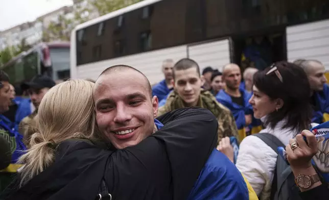 A Ukrainian soldier hugs a woman after returning from captivity in a POW exchange in Ukraine, Tuesday, May 6, 2025. (AP Photo/Evgeniy Maloletka)