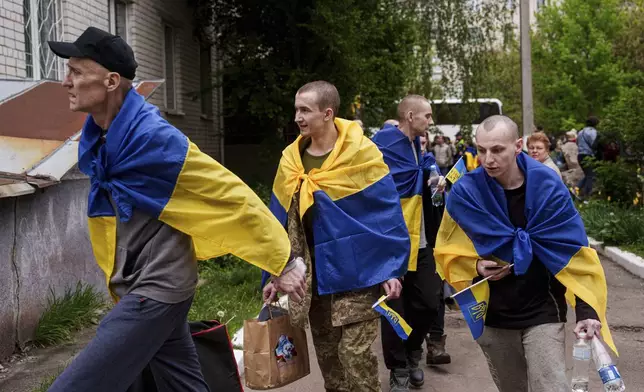 Ukrainian soldier walk out from a bus after returning from captivity in a POW exchange in Ukraine, Tuesday, May 6, 2025. (AP Photo/Evgeniy Maloletka)