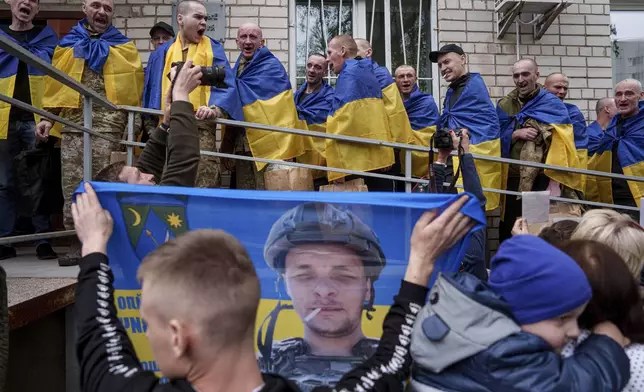 Ukrainian soldiers shout "Glory to Ukraine" after returning from captivity in a POW exchange in Ukraine, Tuesday, May 6, 2025. (AP Photo/Evgeniy Maloletka)