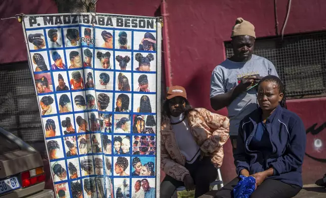 Residents watch the annual Hillbrow street parade organized by the Windybrow Arts Centre and other local organisations go by in downtown Johannesburg, South Africa, Saturday, May 24, 2025. (AP Photo/Jerome Delay)