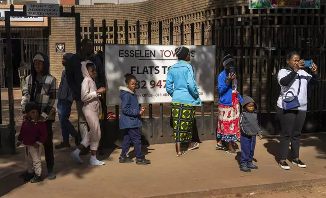 Residents watch the annual Hillbrow street parade organized by the Windybrow Arts Centre and other local organisations go by in downtown Johannesburg, South Africa, Saturday, May 24, 2025. (AP Photo/Jerome Delay)