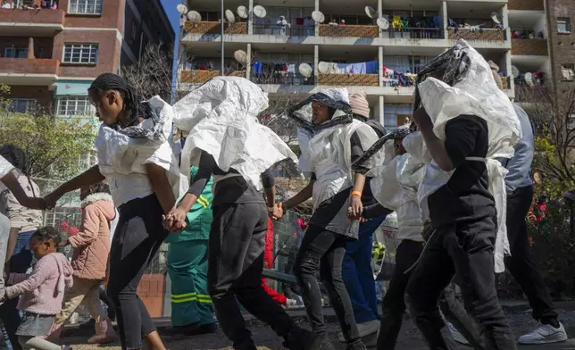 Young girls participate in the annual Hillbrow street parade organized by the Windybrow Arts Centre and other local organisations in downtown Johannesburg, South Africa, Saturday, May 24, 2025. (AP Photo/Jerome Delay)