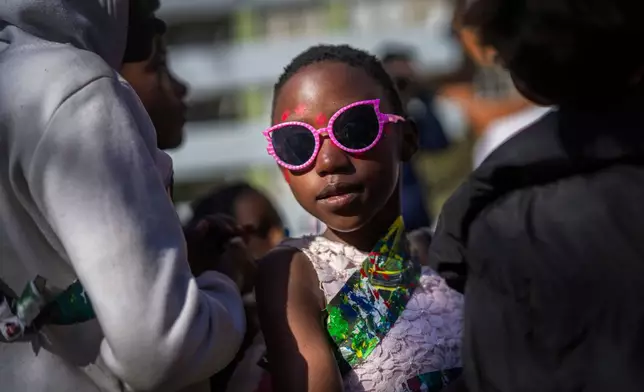 A young girl participates in the annual Hillbrow street parade organized by the Windybrow Arts Centre and other local organisations in downtown Johannesburg, South Africa, Saturday, May 24, 2025. (AP Photo/Jerome Delay)