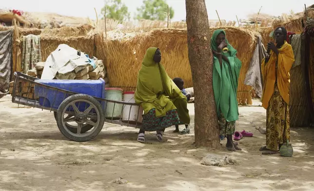 Women displaced by Boko haram attacks are seen outside there camp in Dikwa, north east Nigeria, April 29, 2025. (AP Photo/Sunday Alamba)