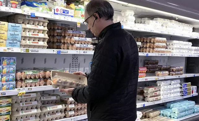FILE - A shopper checks eggs before he purchases at a grocery store in Glenview, Ill., Tuesday, Jan. 10, 2023. (AP Photo/Nam Y. Huh, File)