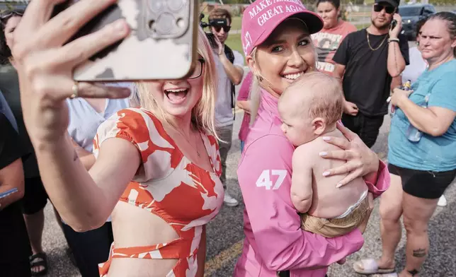 A fan and her child pose for a photo with Savannah Chrisley, daughter of reality television star Todd Chrisley, after she spoke outside the Federal Prison Camp, Wednesday, May 28, 2025, in Pensacola, Fla. (AP Photo/Dan Anderson)