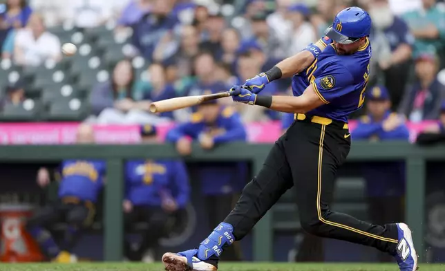 Seattle Mariners' Cal Raleigh hits a three-run home run that scored J.P. Crawford and Jorge Polanco during the first inning of a baseball game against the Minnesota Twins, Friday, May 30, 2025, in Seattle. Raleigh became the first catcher in MLB history to record 20 home runs before the month of June. (AP Photo/Ryan Sun)