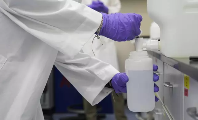 FILE - Logan Feeney pours a water sample with forever chemicals, known as PFAS, into a container for research, April 10, 2024, at a U.S. Environmental Protection Agency lab in Cincinnati. (AP Photo/Joshua A. Bickel, File)