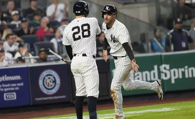 New York Yankees' Cody Bellinger, right, celebrates scoring a run with Austin Wells (28) during the third inning of a baseball game against the New York Mets Friday, May 16, 2025, in New York. (AP Photo/Seth Wenig)