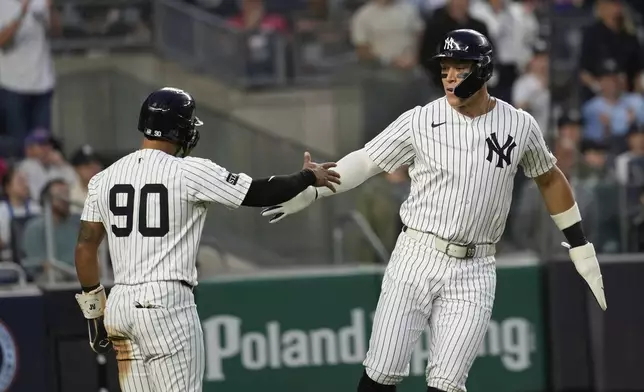 New York Yankees' Aaron Judge, right, celebrates with Jorbit Vivas (90) after they scored on a hit by Paul Goldschmidt during the third inning of a baseball game against the New York Mets Friday, May 16, 2025, in New York. (AP Photo/Seth Wenig)