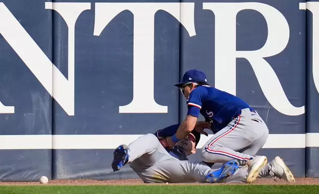 Texas Rangers center fielder Sam Haggerty (0), right, and left fielder Wyatt Langford (36) collide trying to catch a fly ball from Chicago White Sox pinch hitter Austin Slater (15) during the sixth inning of a baseball game Saturday, May 24, 2025, in Chicago. (AP Photo/Erin Hooley)