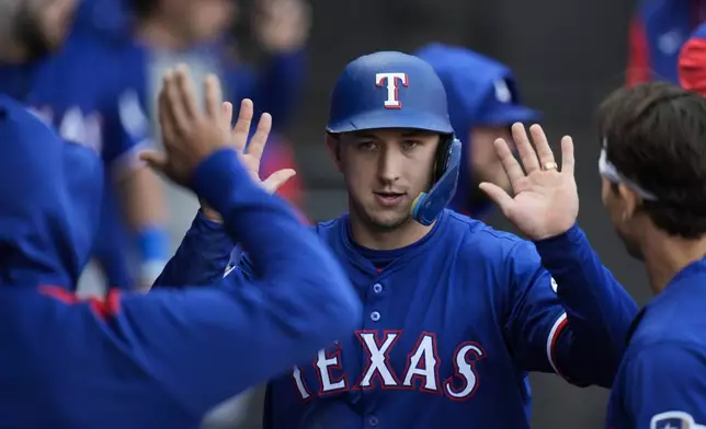 Texas Rangers' Wyatt Langford celebrates after scoring on a single by Texas Rangers designated hitter Kyle Higashioka during the fifth inning of a baseball game against the Chicago White Sox, Saturday, May 24, 2025, in Chicago. (AP Photo/Erin Hooley)