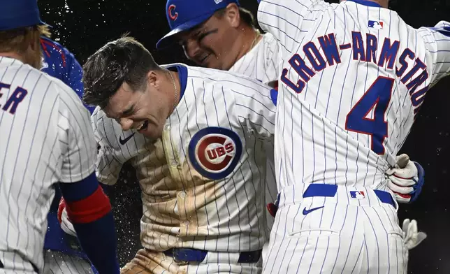 Chicago Cubs' Matt Shaw, center, celebrates with teammates after hitting a walk-off single to defeat the Colorado Rockies in the eleventh inning of a baseball game, Tuesday, May 27, 2025, in Chicago. (AP Photo/Paul Beaty)
