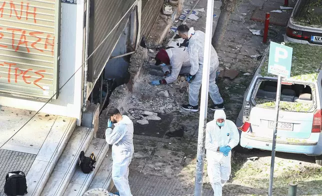 Greek police forensic experts search the spot where a 38-year-old woman was killed early Saturday when a bomb she was carrying exploded in her hands, local police said, in Thessaloniki, northern Greece, May 3, 2025. (AP Photo/Giannis Papanikos)