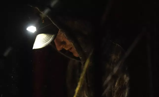Mike Shelton works to attach a hitch to a vehicle as he loads up his belongings at a homeless encampment in Deschutes National Forest Wednesday, April 30, 2025 near Bend, Ore. (AP Photo/Jenny Kane)