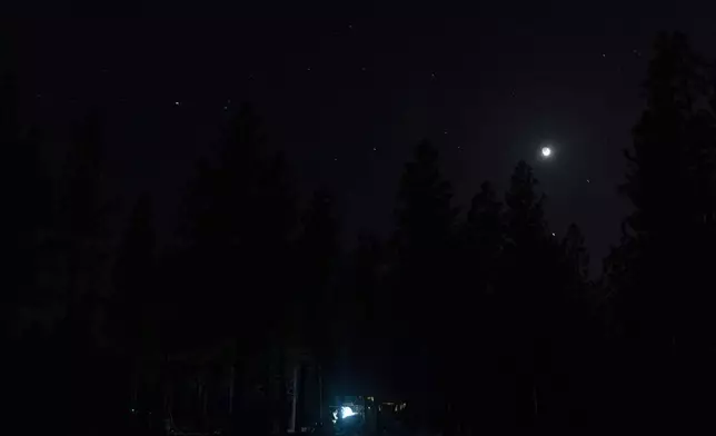 Greg Bishop works to get an RV to start at a homeless encampment in Deschutes National Forest, Wednesday, April 30, 2025 near Bend, Ore. (AP Photo/Jenny Kane)