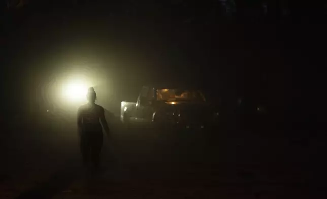 Mandy Bryant walks to help Mike Shelton with his trailer as they load up their belongings at a homeless encampment in Deschutes National Forest, Wednesday, April 30, 2025, near Bend, Ore. (AP Photo/Jenny Kane)