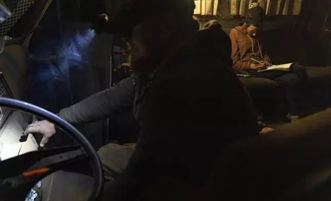 Chris Daggett works to get an RV to start so that it can be moved at a homeless encampment in Deschutes National Forest Wednesday, April 30, 2025 near Bend, Ore. (AP Photo/Jenny Kane)