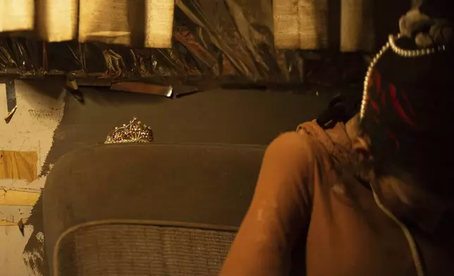 A tiara rests on a seat as a woman writes in a journal at a homeless encampment in Deschutes National Forest Wednesday, April 30, 2025 near Bend, Ore. (AP Photo/Jenny Kane)