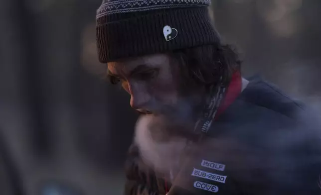 Nick Campbell vapes at a homeless encampment in Deschutes National Forest Wednesday, April 30, 2025 near Bend, Ore. (AP Photo/Jenny Kane)
