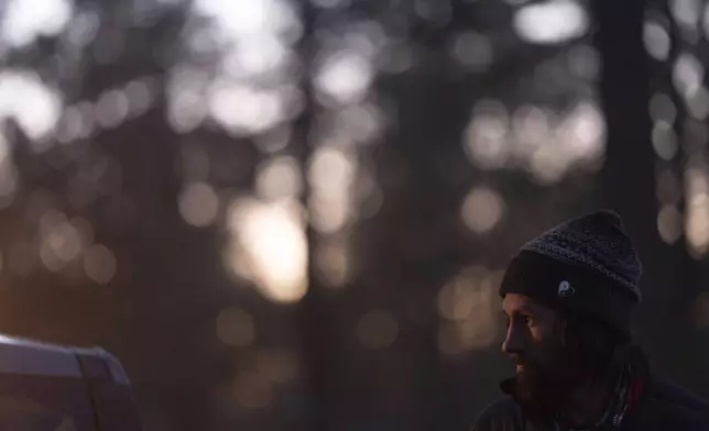 Nick Campbell looks up while talking to a volunteer at a homeless encampment in Deschutes National Forest Wednesday, April 30, 2025 near Bend, Ore. (AP Photo/Jenny Kane)