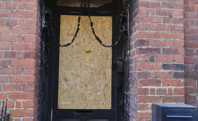 Fire damage is seen in the doorway of a house belonging to British Prime Minister Keir Starmer in Kentish Town in London, Tuesday, May 13, 2025. (AP Photo/Kirsty Wigglesworth)