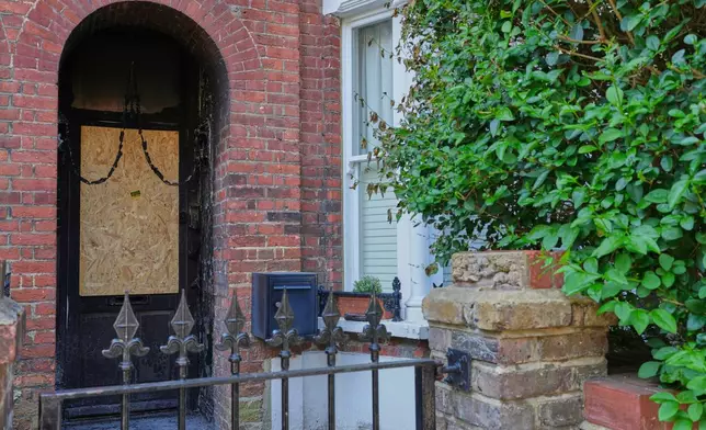 Fire damage is seen in the doorway of a house belonging to British Prime Minister Keir Starmer in Kentish Town in London, Tuesday, May 13, 2025. (AP Photo/Kirsty Wigglesworth)