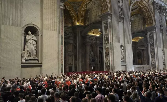 Faithful capture images with their smartphones of cardinals arriving during a final Mass inside St. Peter's Basilica before the conclave to elect a new pope, at the Vatican, Wednesday, May 7, 2025. (AP Photo/Gregorio Borgia)