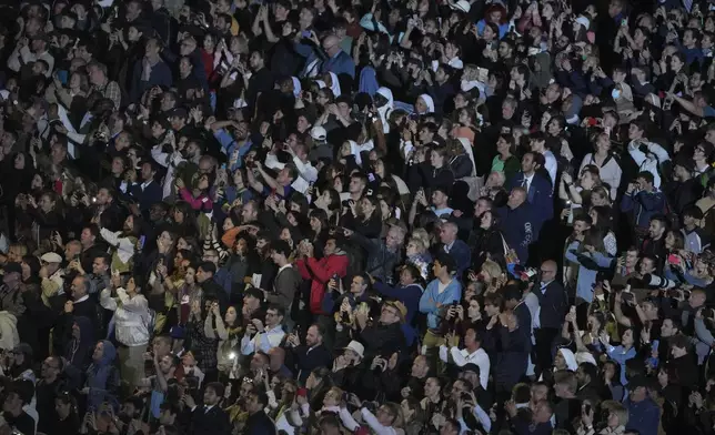 People react in St. Peter's Square at the Vatican after black smoke billowed from the chimney of the Sistine Chapel, where 133 cardinals are gathering on the first day of the conclave, indicating that a successor of late Pope Francis was not elected, Wednesday, May 7, 2025. (AP Photo/Markus Schreiber)