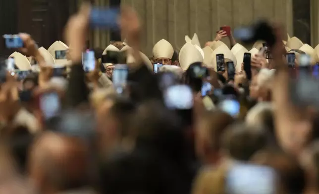 Faithful capture images with their smartphones of cardinals during a final Mass inside St. Peter's Basilica before the conclave to elect a new pope, at the Vatican, Wednesday, May 7, 2025. (AP Photo/Gregorio Borgia)