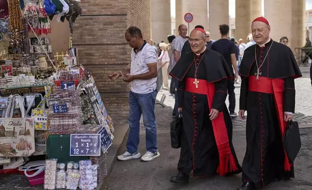 Cardinal José Tolentino de Mendonça, left, walks with Cardinal Gianfranco Ravasi at the Vatican, Tuesday, May 6, 2025. (AP Photo/Bernat Armangue)