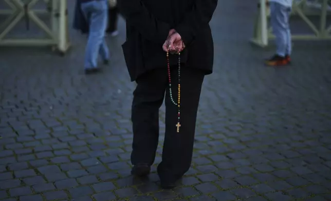 A priest walks along St. Peter's square, at the Vatican, on Tuesday, May 6, 2025, the day before of the upcoming conclave starting on May 7, to elect the 267th Roman pontiff. (AP Photo/Francisco Seco)