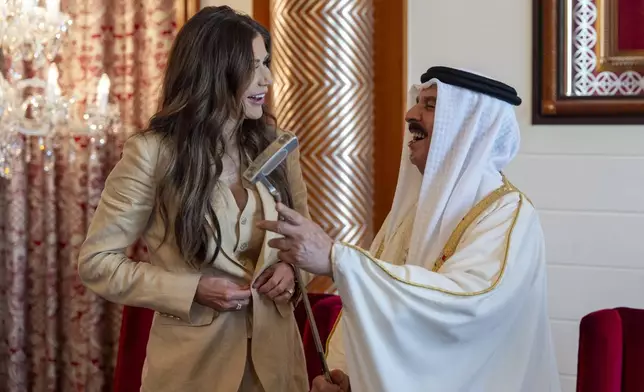 Homeland Security Secretary Kristi Noem gives Bahrain's King Hamad bin Isa Al Khalifa a golf club after their meeting at the Sakhir Royal Palace, Sunday, May 25, 2025, in Manama, Bahrain. (AP Photo/Alex Brandon, Pool)