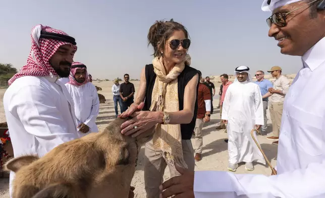 Homeland Security Secretary Kristi Noem pets a camel before a tour Qal'at al-Bahrain Fort, Sunday, May 25, 2025, near Manama, Bahrain. (AP Photo/Alex Brandon, Pool)