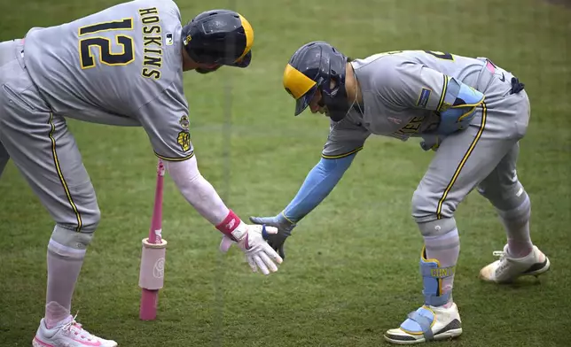 Milwaukee Brewers' Christian Yelich, right, celebrates after his solo home run with Rhys Hoskins (12) during the fourth inning of a baseball game against the Tampa Bay Rays, Sunday, May 11, 2025, in Tampa, Fla. (AP Photo/Phelan M. Ebenhack)