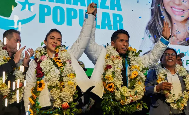 Bolivian Senate President Andronico Rodriguez, right, and running mate Mariana Prado raise their arms at a ceremony announcing their presidential candidacy for the Alianza Popular (Popular Alliance) party, in La Paz, Bolivia, Monday, May 19, 2025. (AP Photo/Juan Karita)