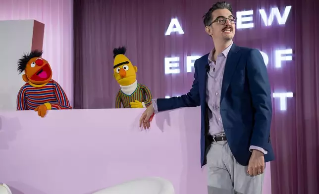 Sal Perez, executive producer and VP of Sesame Street at Sesame Workshop, talks to Bert and Ernie after winning the Elevate Prize Foundation's Catalyst Award, Wednesday, May 14, 2025, in Miami Beach, Fla. (AP Photo/Michael Laughlin)