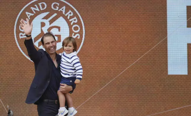 Rafa Nadal holds his son Rafael Junior during a farewell ceremony at center court Philippe-Chatrier, at the Roland-Garros stadium, in Paris, Sunday May 25, 2025. (AP Photo/Thibault Camus)